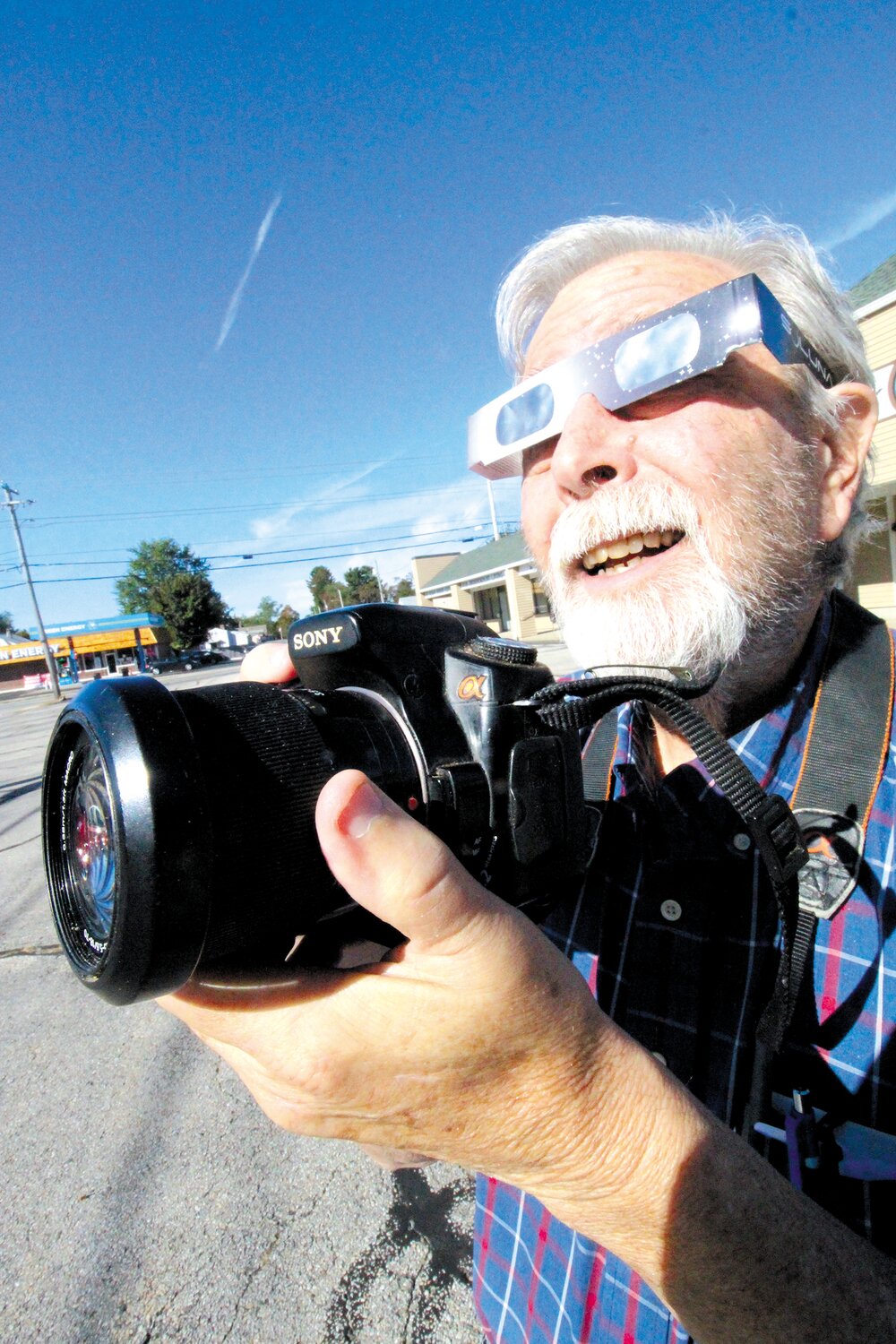 PREPARED TO SHOOT: Cranston Herald photographer Steve Popiel is armed with camera and eclipse-safe glasses to record the partial solar eclipse this Saturday.